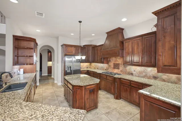a kitchen with granite countertop a sink stainless steel appliances and cabinets