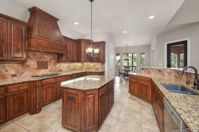 a large kitchen with kitchen island granite countertop a sink and a wooden floors