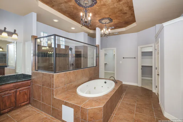 a bathroom with a granite countertop sink a mirror and shower