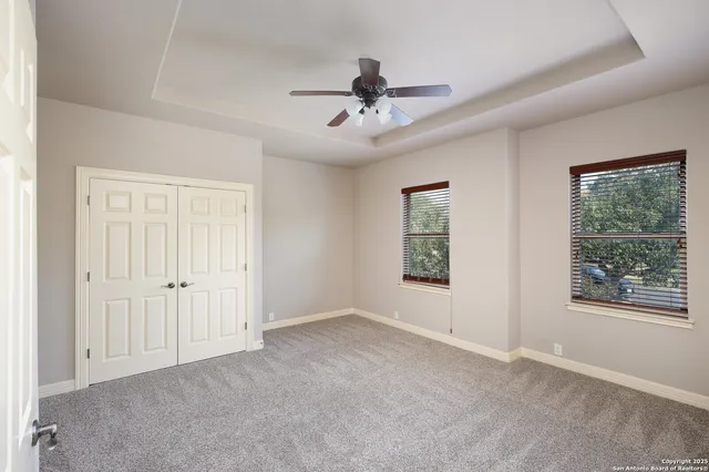 an empty room with windows and fan