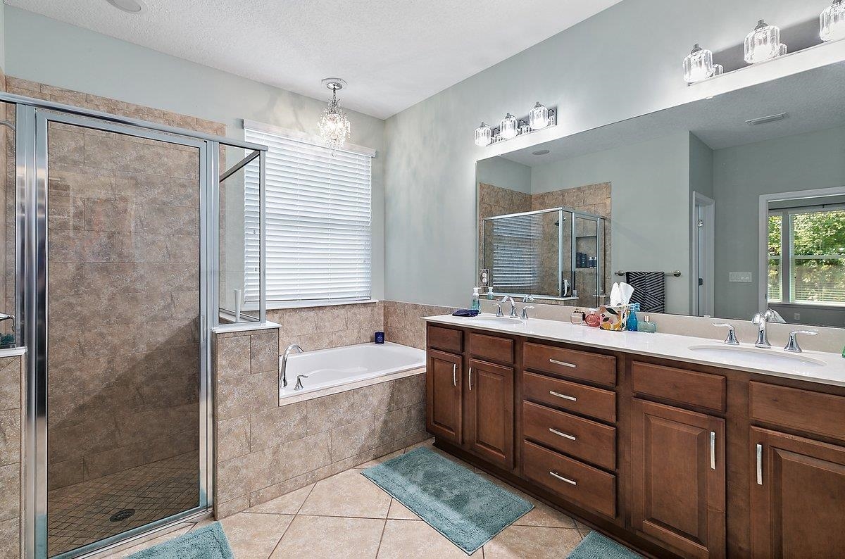 331 Athens Drive St. Augustine, FL 32092 - Photo 12 of 24 a bathroom with a tub a double vanity sink and mirror