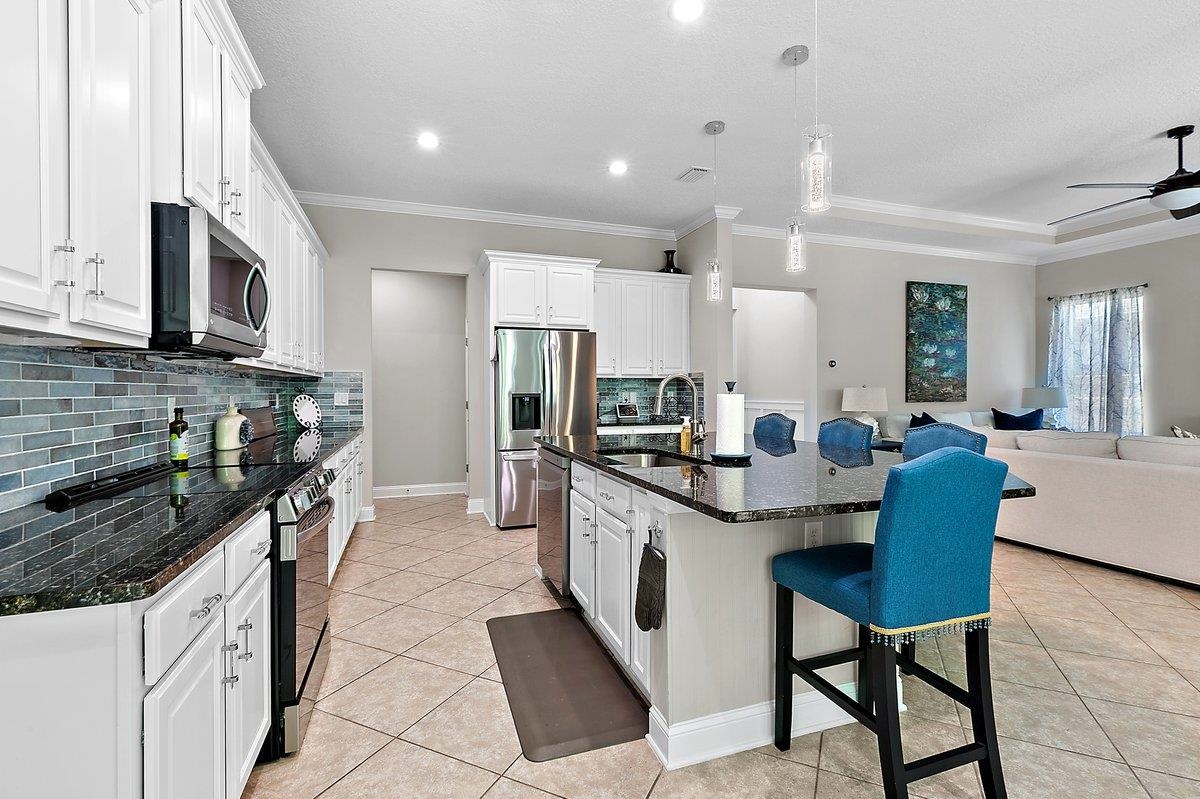 331 Athens Drive St. Augustine, FL 32092 - Photo 7 of 24 a kitchen with stainless steel appliances kitchen island granite countertop a sink and cabinets