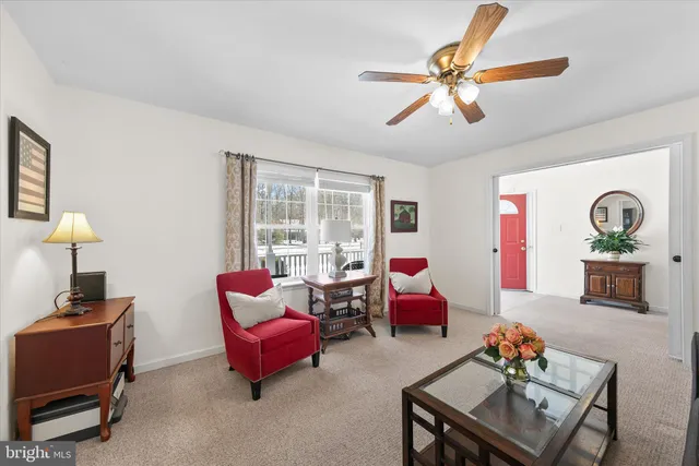 a living room with furniture and a ceiling fan