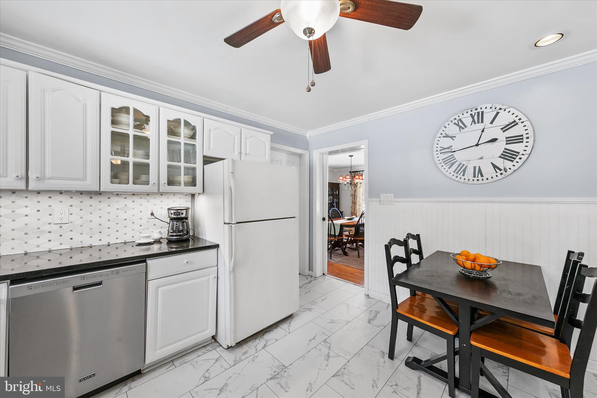 24618 Peterkins Road Georgetown, DE 19947 - Photo 23 of 47 a kitchen with stainless steel appliances granite countertop a dining table chairs and a refrigerator