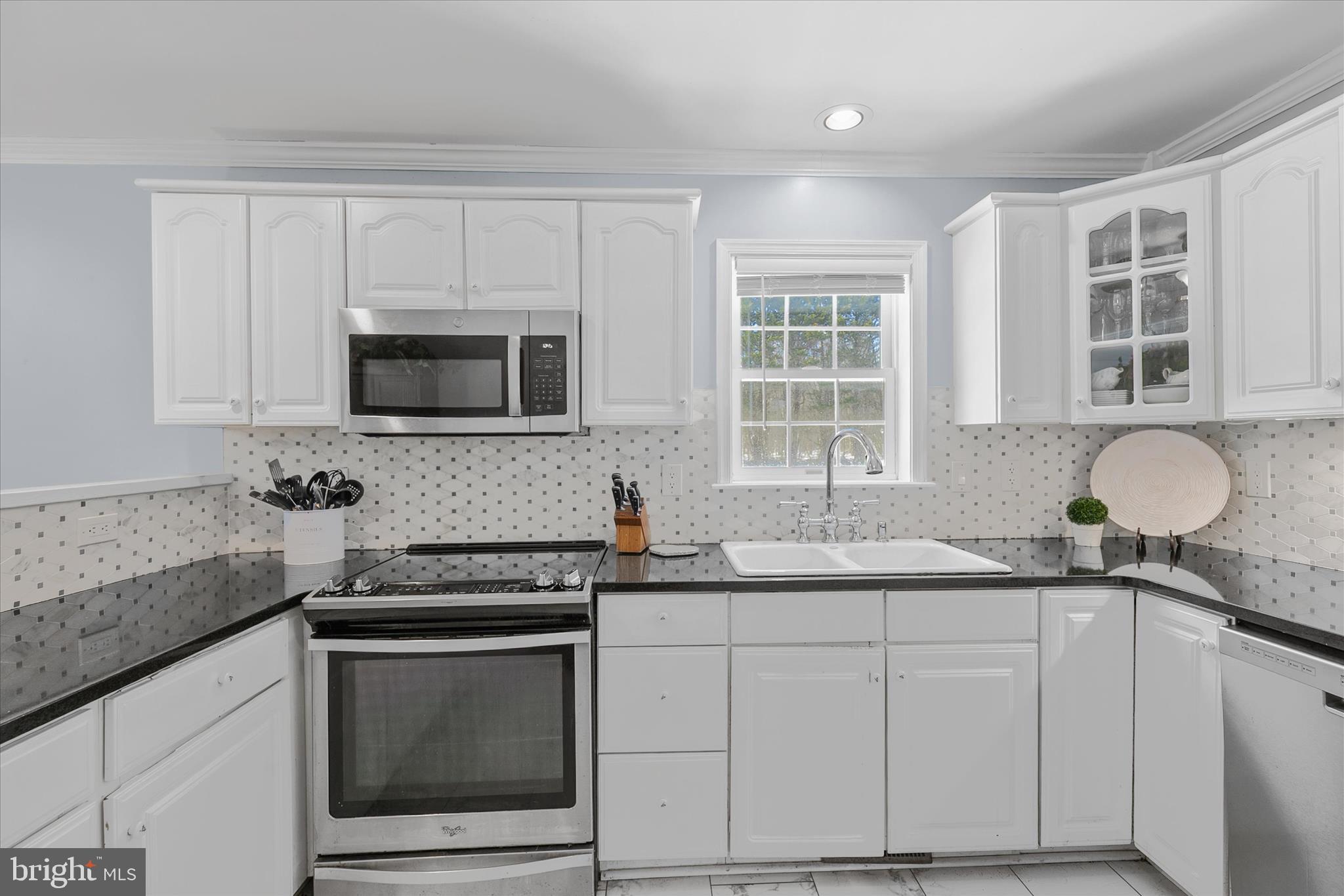 24618 Peterkins Road Georgetown, DE 19947 - Photo 24 of 47 a kitchen with granite countertop white cabinets stainless steel appliances and a sink