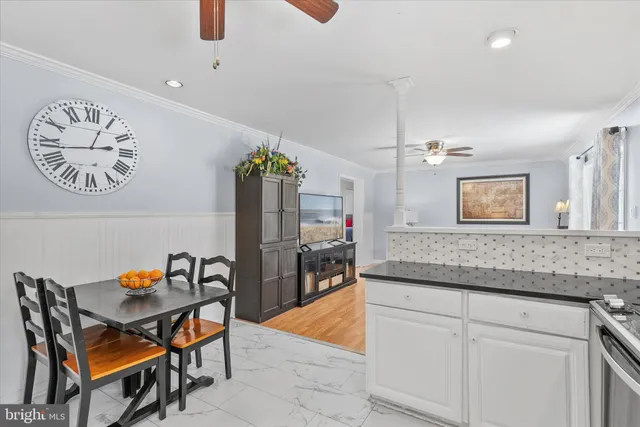 a large kitchen with kitchen island granite countertop lots of white cabinets appliances and furniture