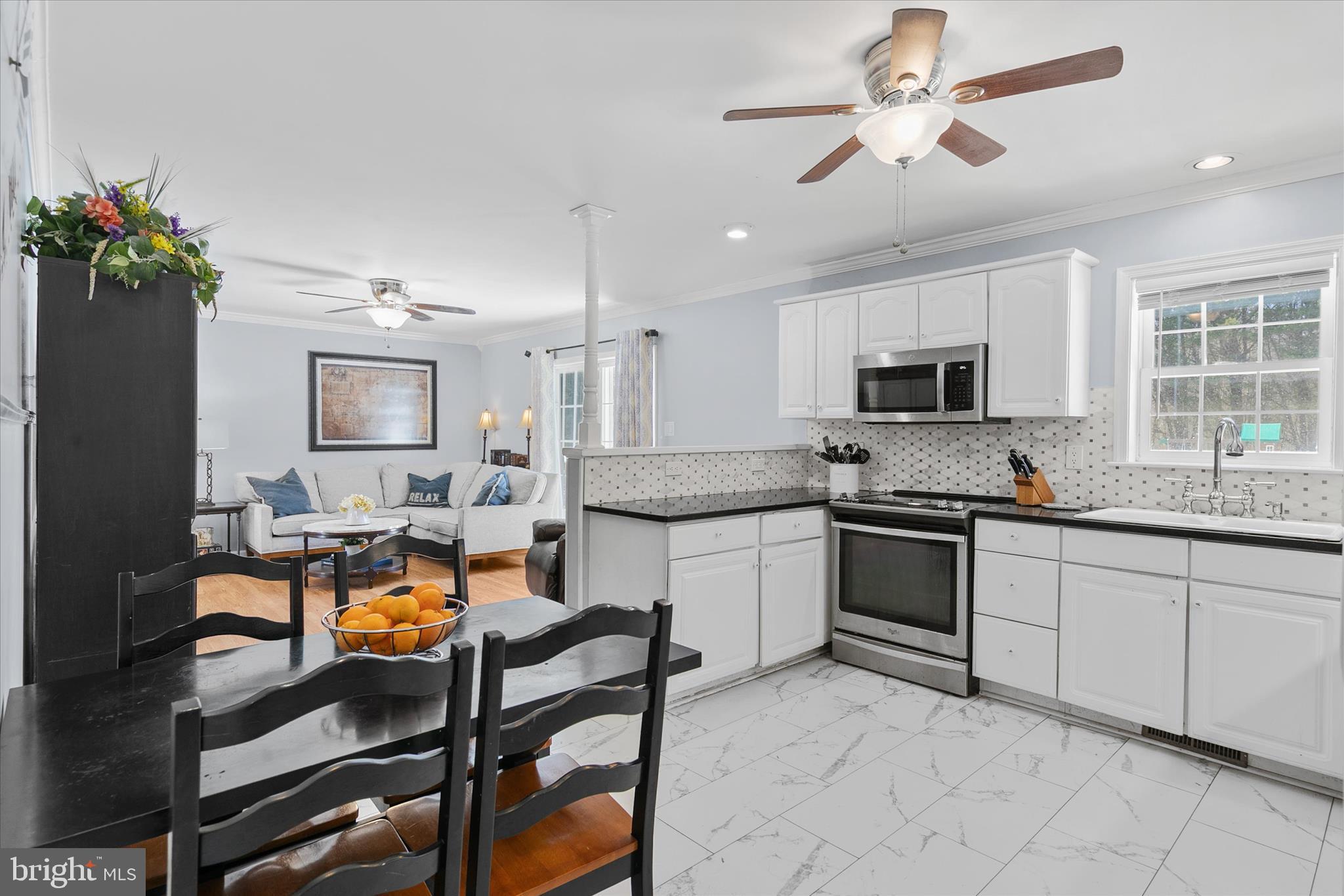 24618 Peterkins Road Georgetown, DE 19947 - Photo 26 of 47 a large kitchen with kitchen island granite countertop lots of white cabinets appliances and furniture