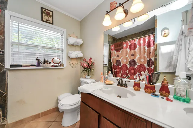 a bathroom with a sink mirror vanity and toilet