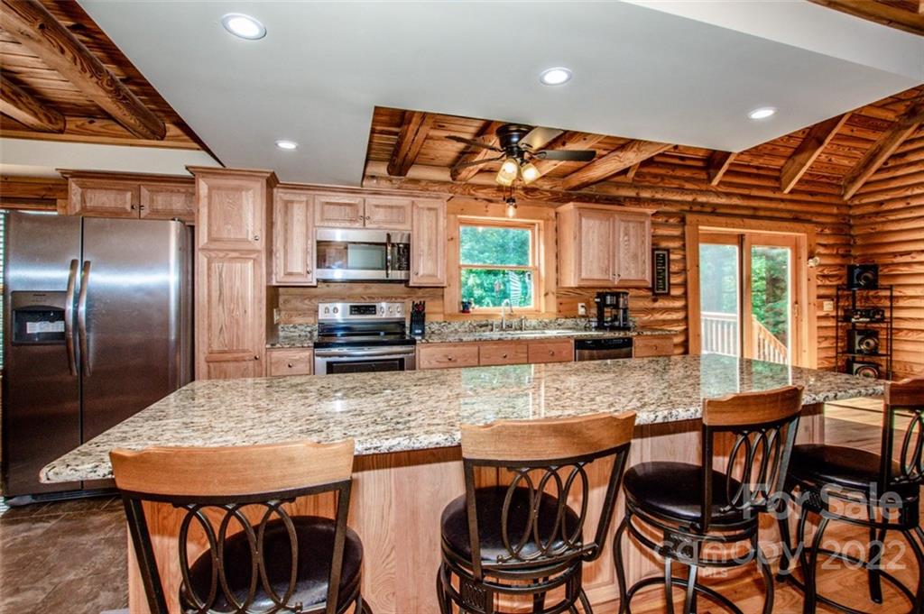 133 Folkstone Road, Unit 2 Mooresville, NC 28117 - Photo 13 of 32 a kitchen with granite countertop a table chairs microwave and refrigerator