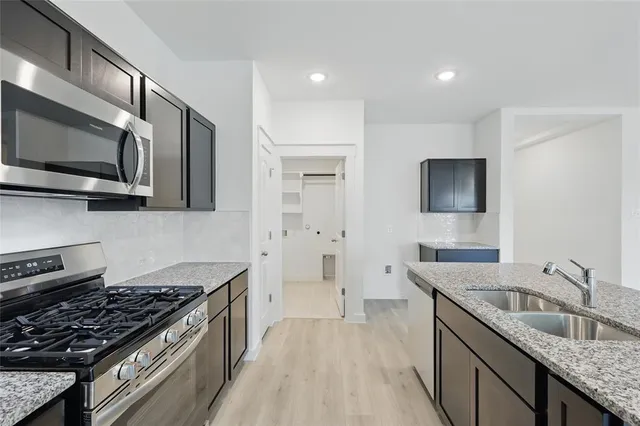 a kitchen with a sink cabinets and wooden floor