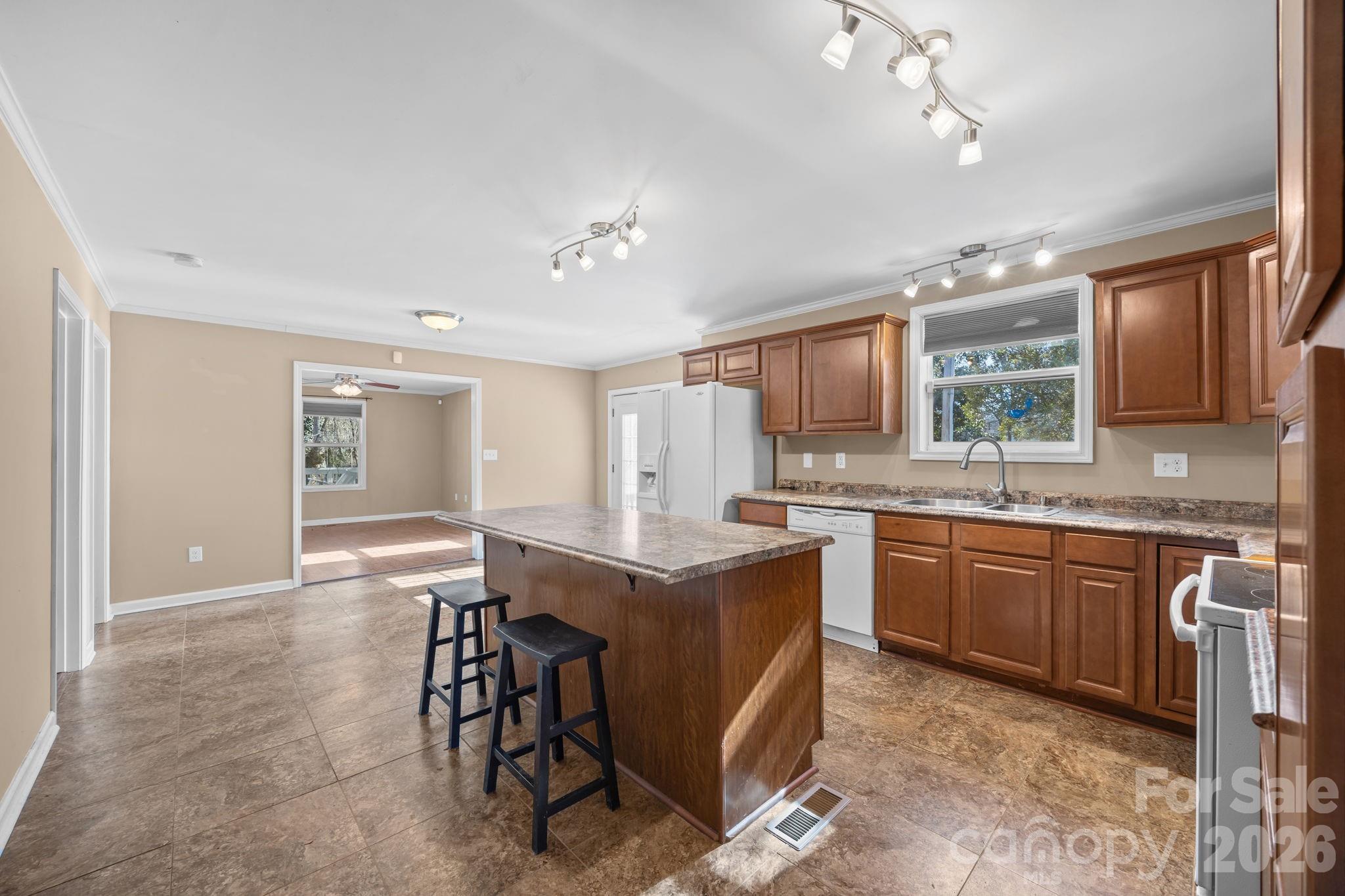 708 Old Charlotte Road Southwest Concord, NC 28027 - Photo 16 of 35 a open kitchen with stainless steel appliances granite countertop a table chairs sink and cabinets