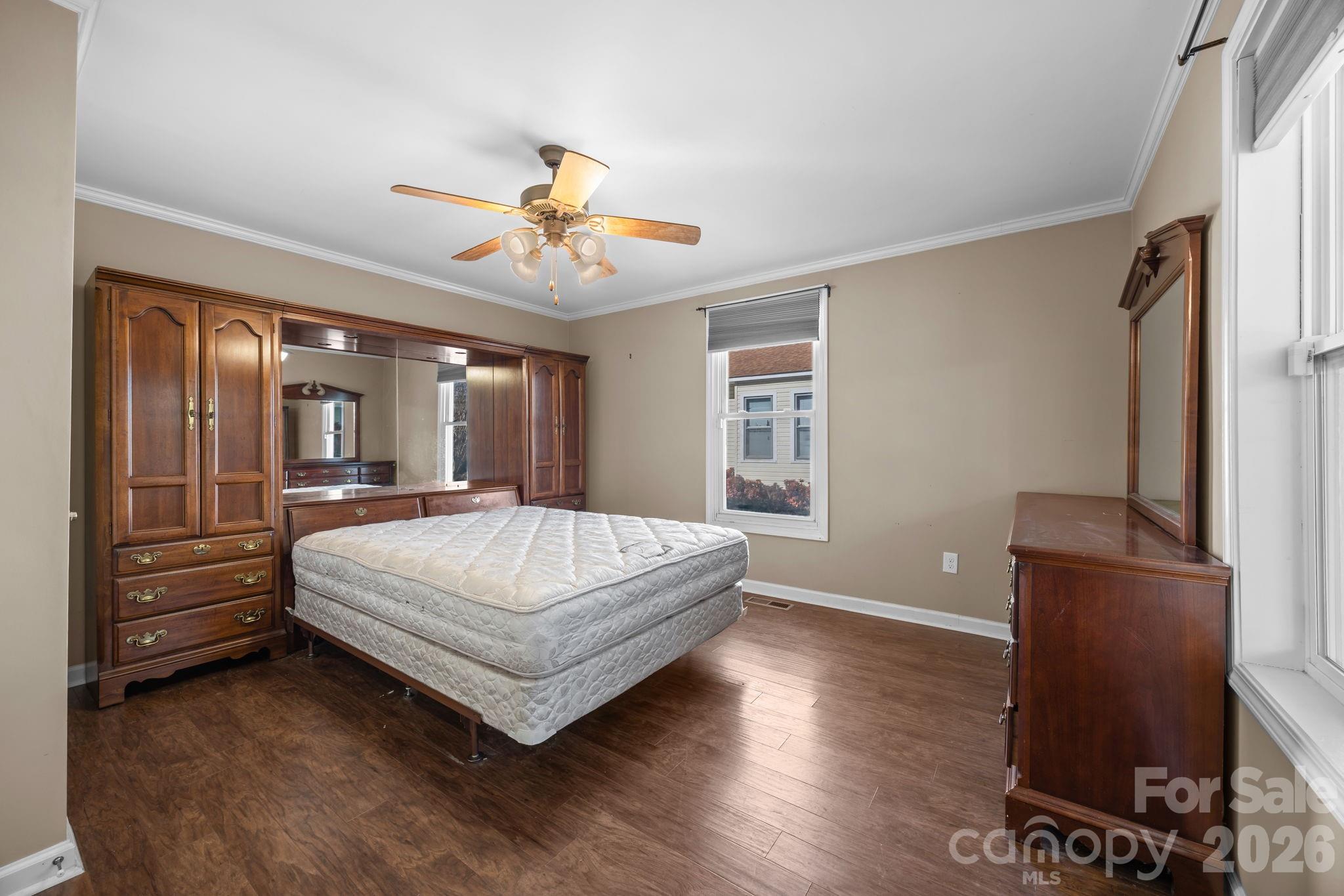 708 Old Charlotte Road Southwest Concord, NC 28027 - Photo 21 of 35 a spacious bedroom with a bed and a chandelier