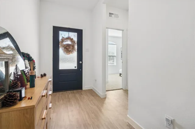a view of a hallway with wooden floor and staircase