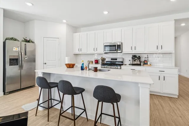 a living room with stainless steel appliances kitchen island furniture and a large window