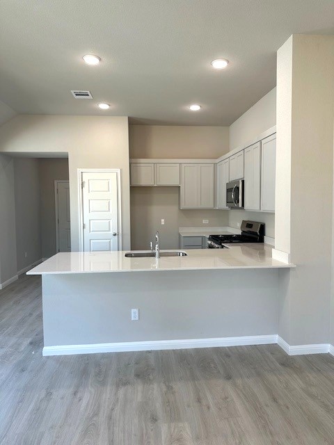 143 Tolo Drive Elgin, TX 78621 - Photo 5 of 30 a living room with stainless steel appliances granite countertop a sink a microwave a refrigerator and white cabinets