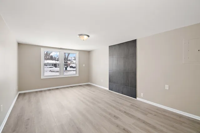 an empty room with wooden floor and window