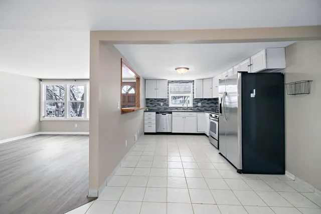 a kitchen with stainless steel appliances granite countertop a refrigerator and a stove top oven