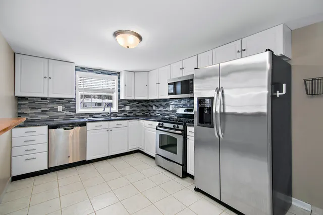 a kitchen with a refrigerator sink and cabinets