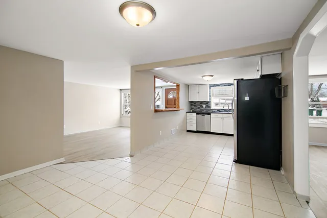 a kitchen with granite countertop a refrigerator and a stove top oven