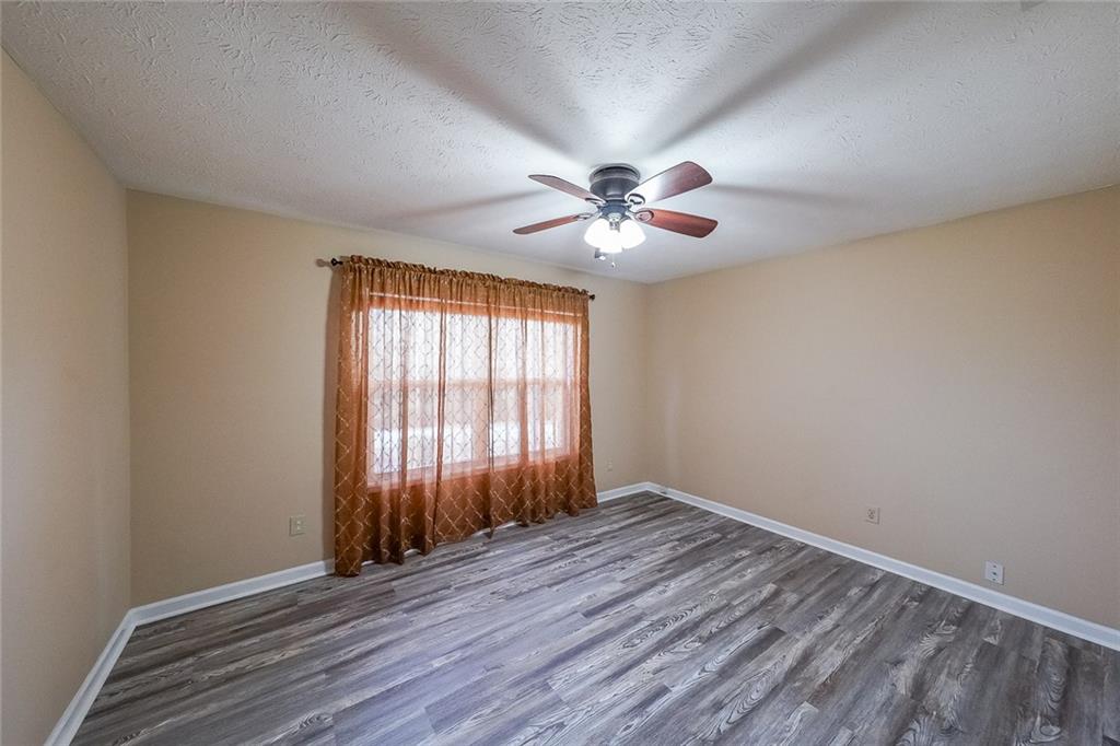 4255 Prestley Mill Road Douglasville, GA 30135 - Photo 23 of 43 an empty room with wooden floor and windows