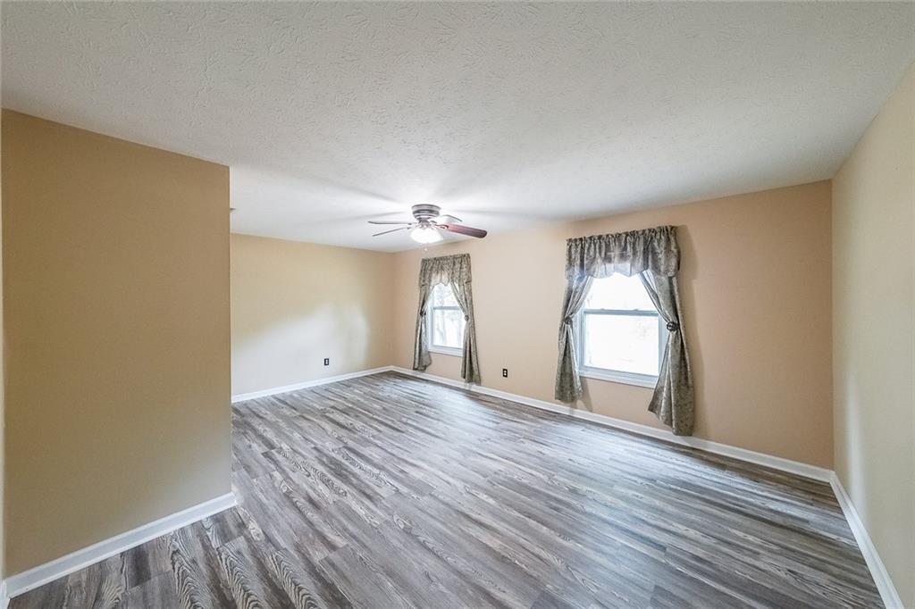 4255 Prestley Mill Road Douglasville, GA 30135 - Photo 24 of 43 an empty room with wooden floor and windows