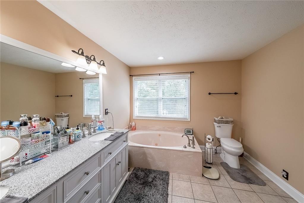 4255 Prestley Mill Road Douglasville, GA 30135 - Photo 31 of 43 a spacious bathroom with a bathtub sink mirror and toilet