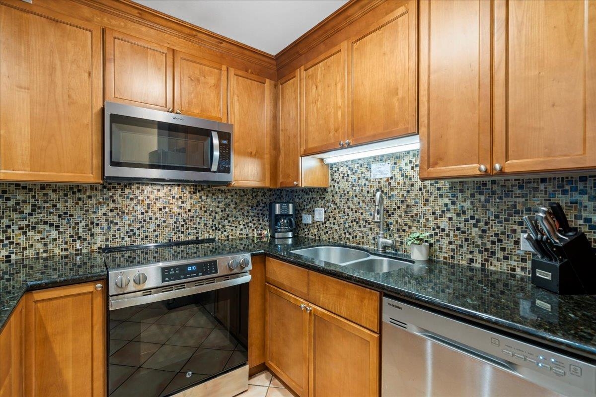 2695 South Kihei Road, Unit 6109 Kihei, HI 96753 - Photo 4 of 49 a kitchen with granite countertop cabinets stainless steel appliances a sink and wooden floor