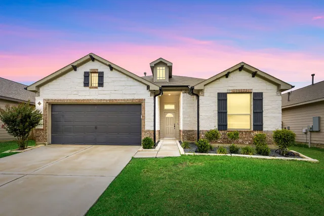 a front view of a house with a yard and garage