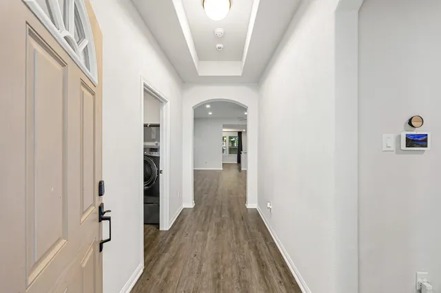an empty room with wooden floor and a ceiling fan
