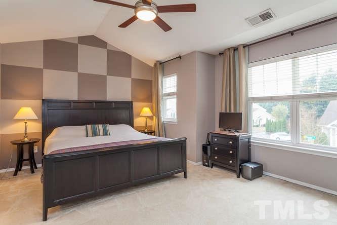8402 Stoneyard Place Raleigh, NC 27613 - Photo 4 of 25 a bedroom with a bed and a chandelier