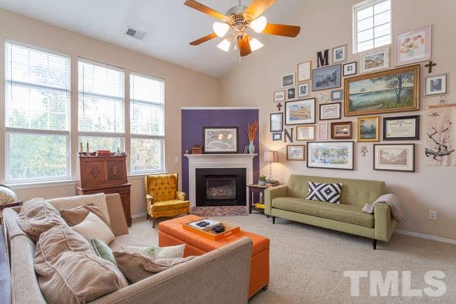 8402 Stoneyard Place Raleigh, NC 27613 - Photo 10 of 25 a living room with furniture a fireplace and a large window