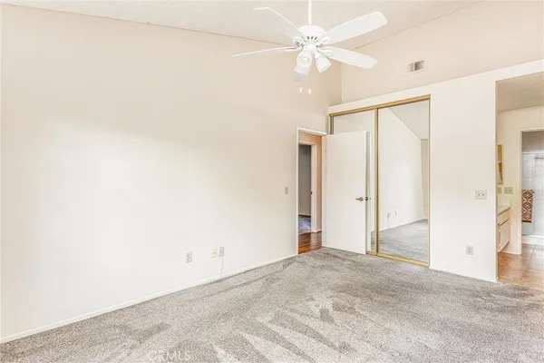 an empty room with a ceiling fan and a window