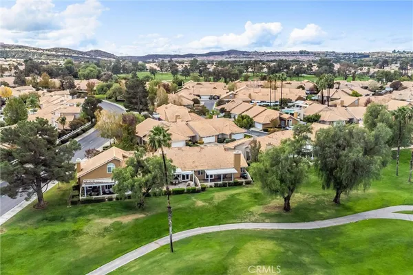 an aerial view of residential houses with outdoor space and trees