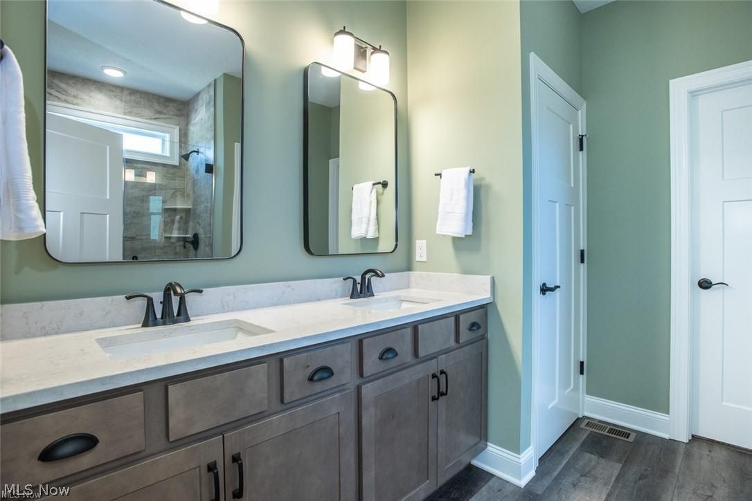 34286 Brookside Lane North Ridgeville, OH 44039 - Photo 26 of 50 Full bathroom with double vanity, dark wood-type flooring, and tiled shower