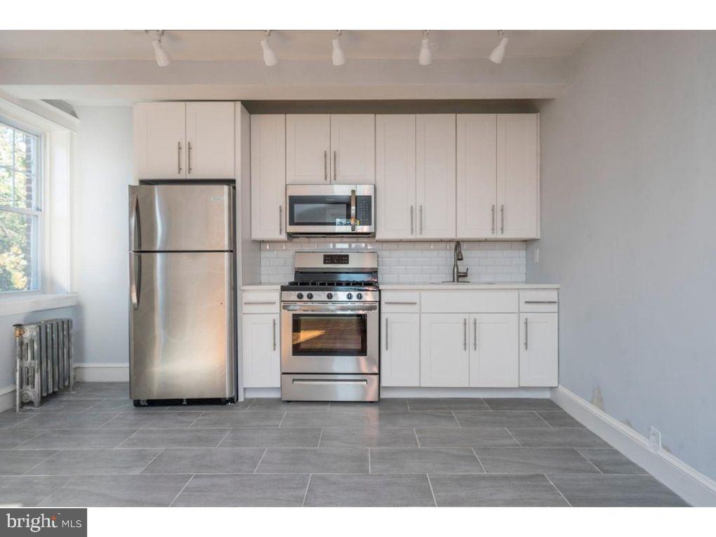 320 Rochelle Avenue, Unit 32 Philadelphia, PA 19128 - Photo 11 of 19 a kitchen with a refrigerator sink and cabinets
