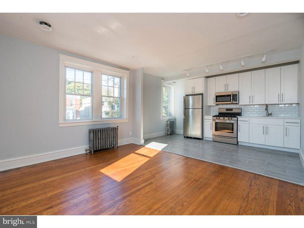 320 Rochelle Avenue, Unit 32 Philadelphia, PA 19128 - Photo 5 of 19 a kitchen with stainless steel appliances granite countertop a stove a refrigerator and a sink with wooden cabinets