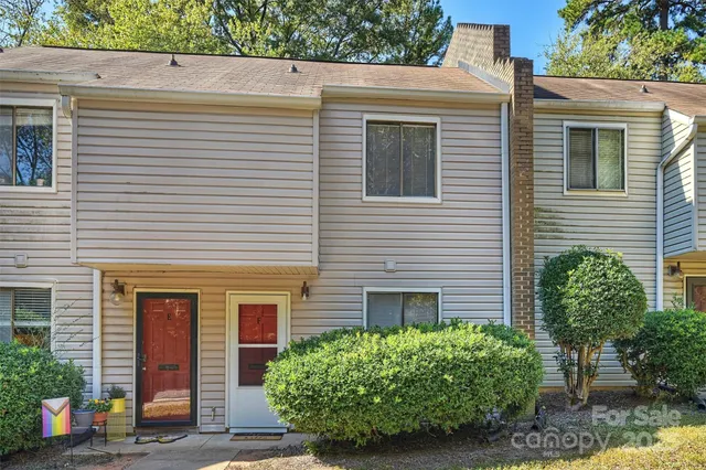 a view of a house with potted plants and a large window