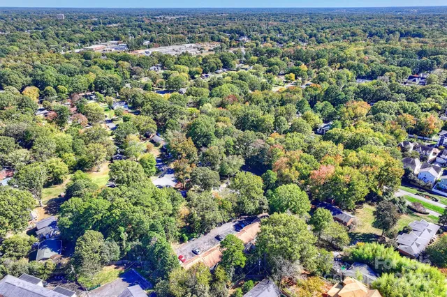 an aerial view of a houses with a lush green hillside