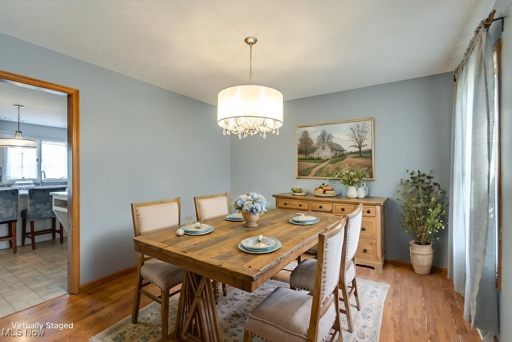 5613 Stoney Ridge Road Northwest Canton, OH 44718 - Photo 11 of 39 Dining room featuring light wood finished floors and a chandelier