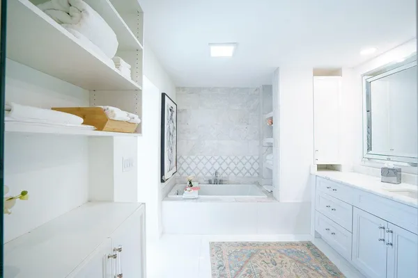 a bathroom with a tub sink and mirror