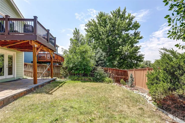a view of a balcony with chairs and wooden fence