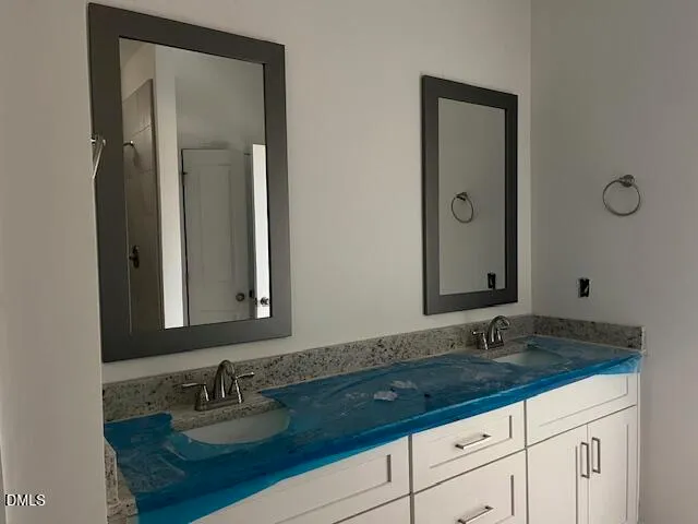 a bathroom with double vanity sinks and a mirror
