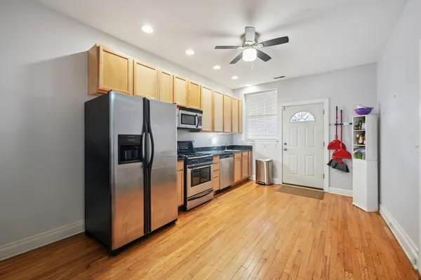 a kitchen with stainless steel appliances granite countertop a refrigerator a stove a sink and a microwave