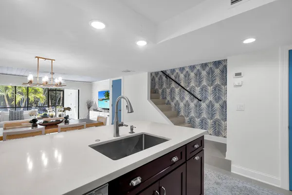 a living room with furniture a chandelier and a dining table with wooden floor