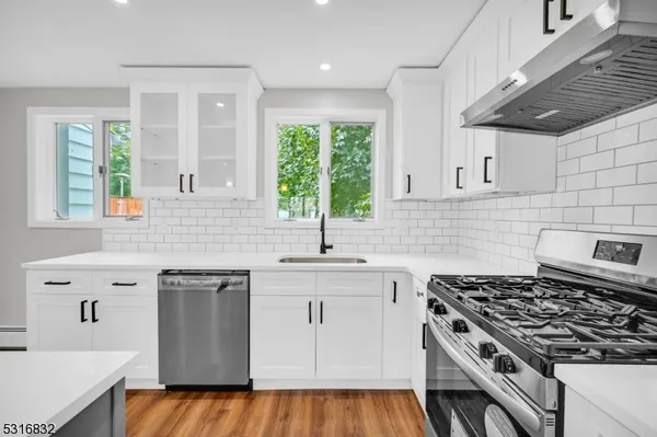 a kitchen with stainless steel appliances a sink a stove a counter space and a window