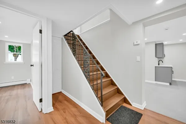 a view of a hallway with wooden floor and staircase