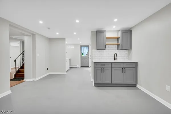 a view of cabinets a sink a window and stainless steel appliances