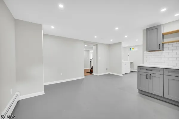 a view of an empty room with window and cabinet