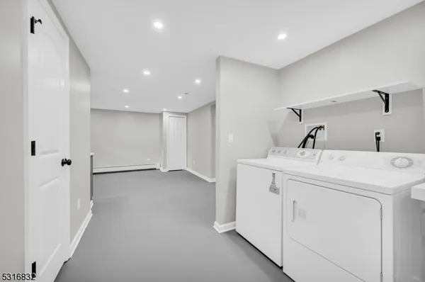 a view of storage and utility room with closet dryer and washer