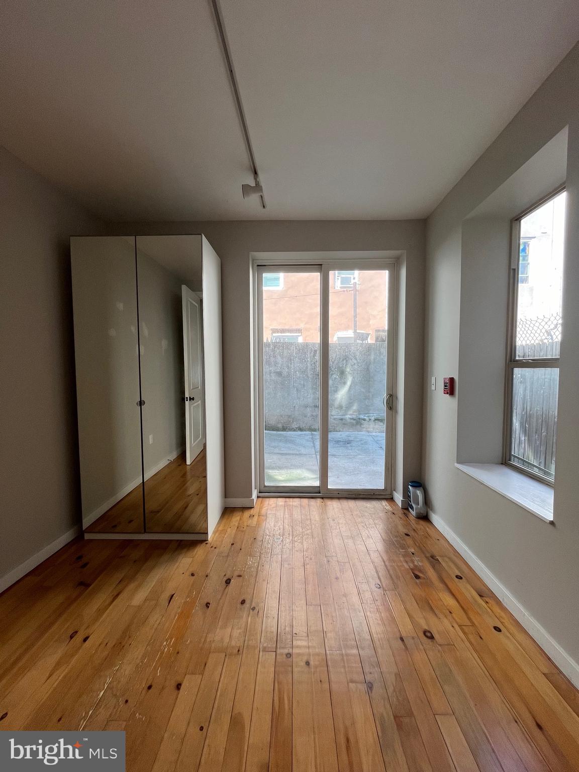 1208 North 4th Street, Unit 1 Philadelphia, PA 19122 - Photo 4 of 10 a view of an empty room with wooden floor and a window